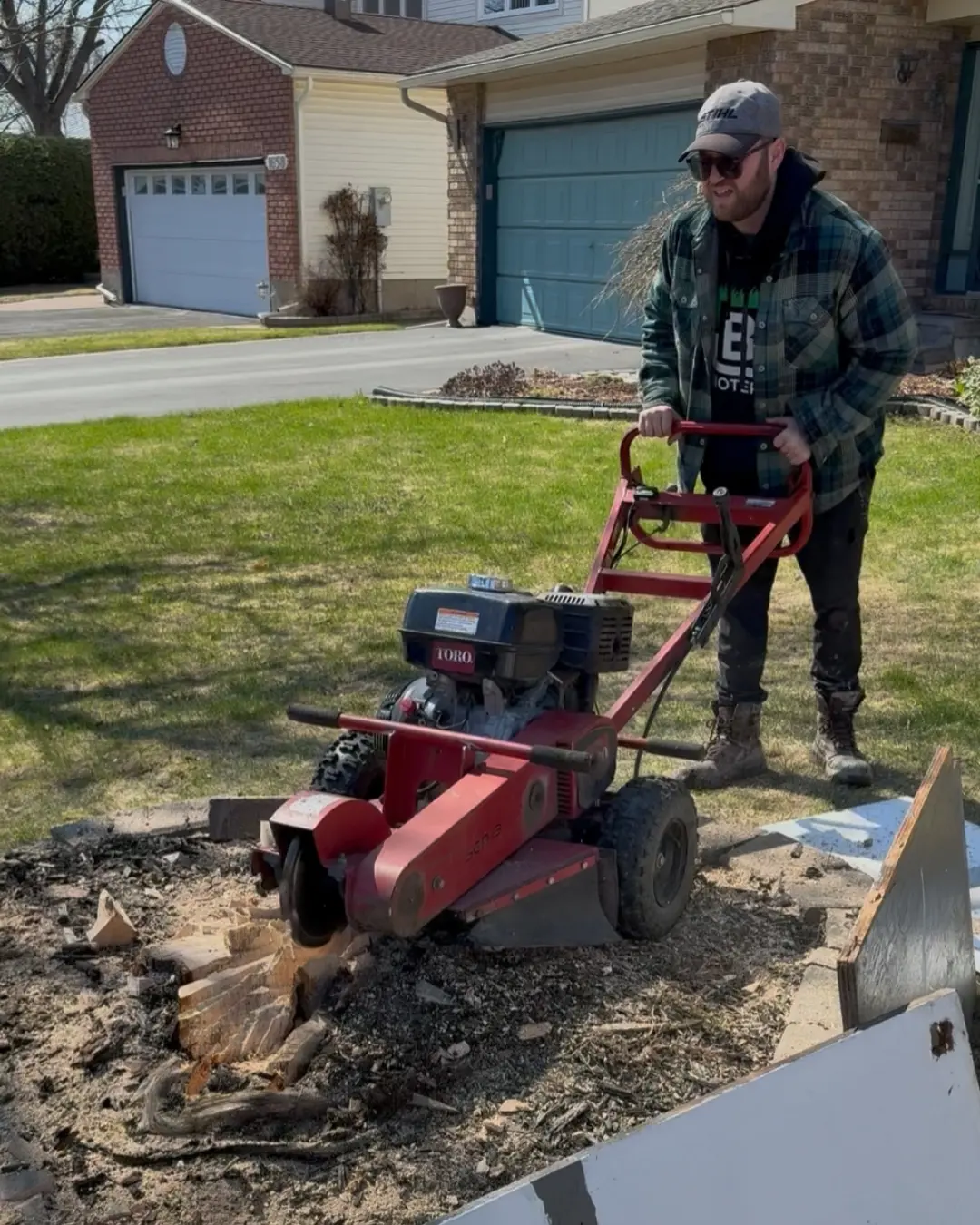 Ottawa Professional Stump Grinding Service Professional stump grinding service in Ottawa removing a large tree stump from a residential front yard using commercial stump grinder equipment.